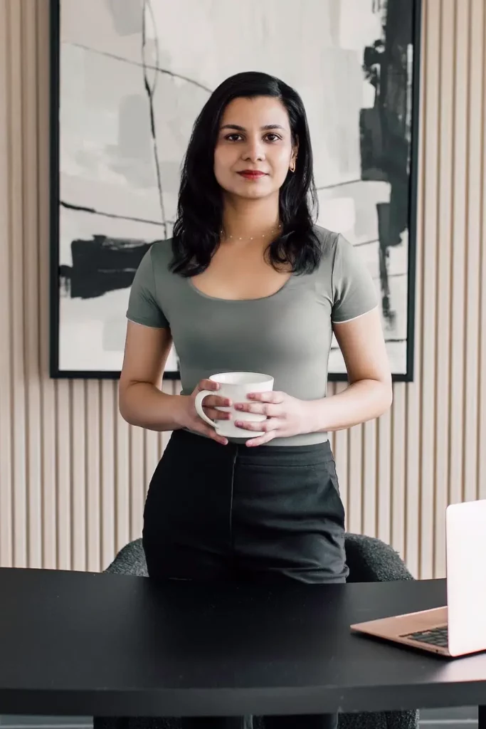 Psychotherapist Regina d cruz standing with a mug in a beautiful office